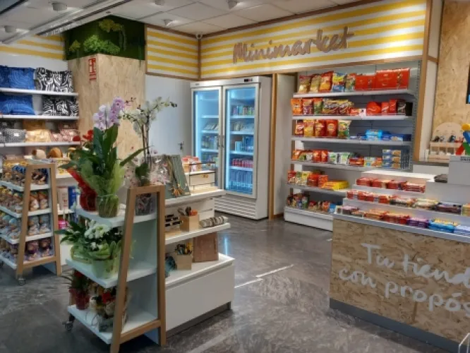 Se muestra el interior de la tienda con productos como flores, muñecos, snacks, bebidas frías y mucho más