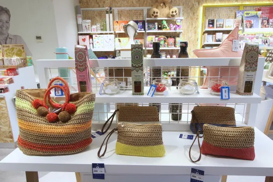 Un expositor de bolsos con múltiples colores y otros productos visibles de fondo.